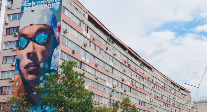 Il volto di David Popovici su un edificio di Bucarest.